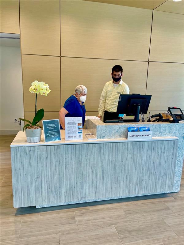 Image of a worker and Student at the front desk at a local Hotel Job site